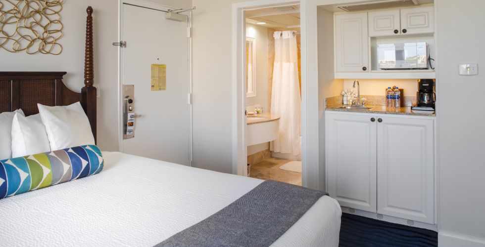 A Bedroom With A Bed And A Mirror In A Room