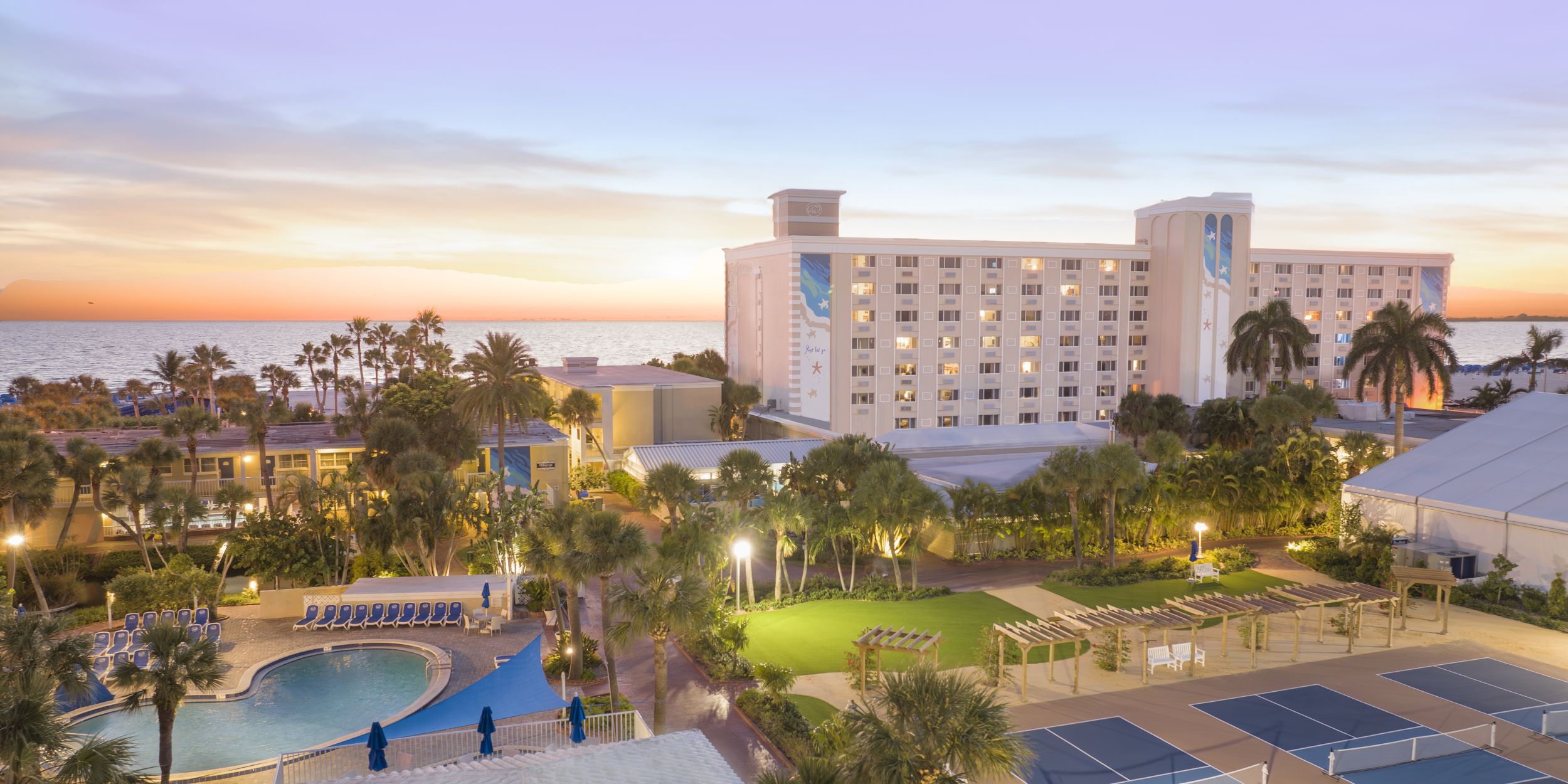A Building With A Pool And Trees In Front Of It