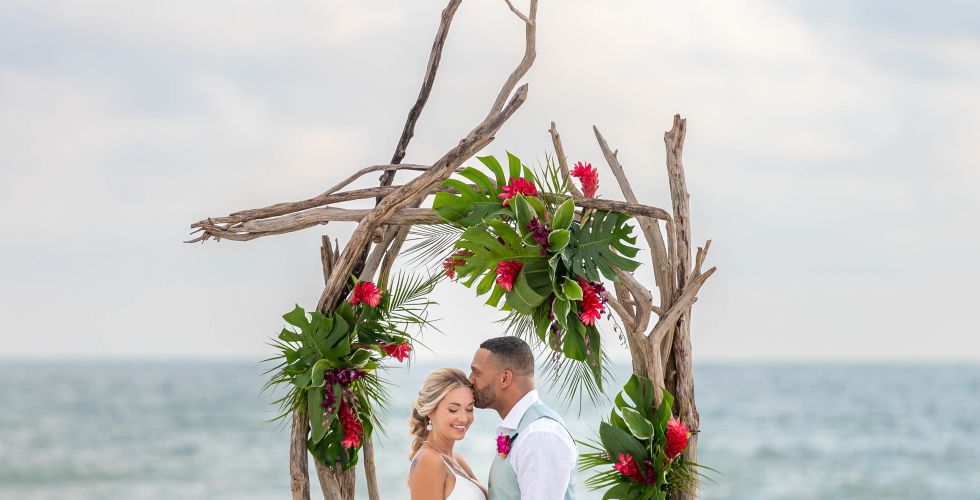 A Man And Woman In Wedding Attire On A Beach