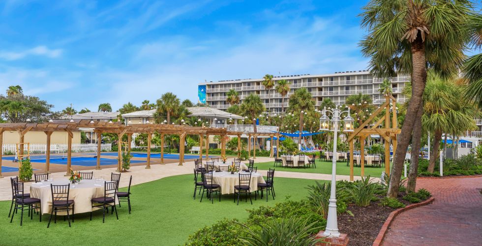 A Patio With Tables And Chairs By A Pool And A Building