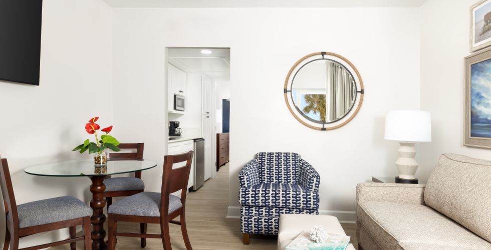 A Living Room With A Round Mirror