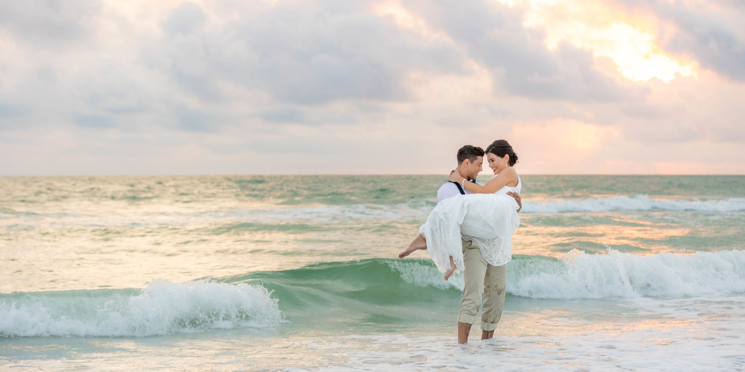 A Man And Woman Holding Each Other On A Beach