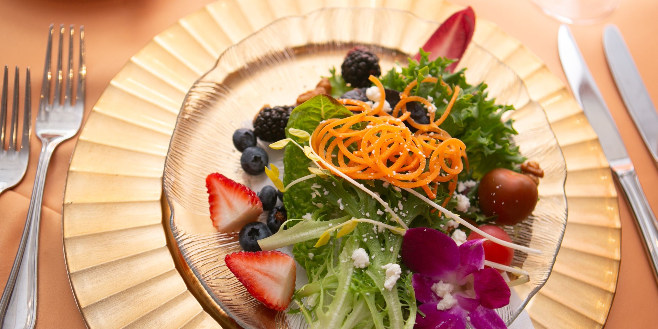 A Plate Of Salad With Fruit And Vegetables