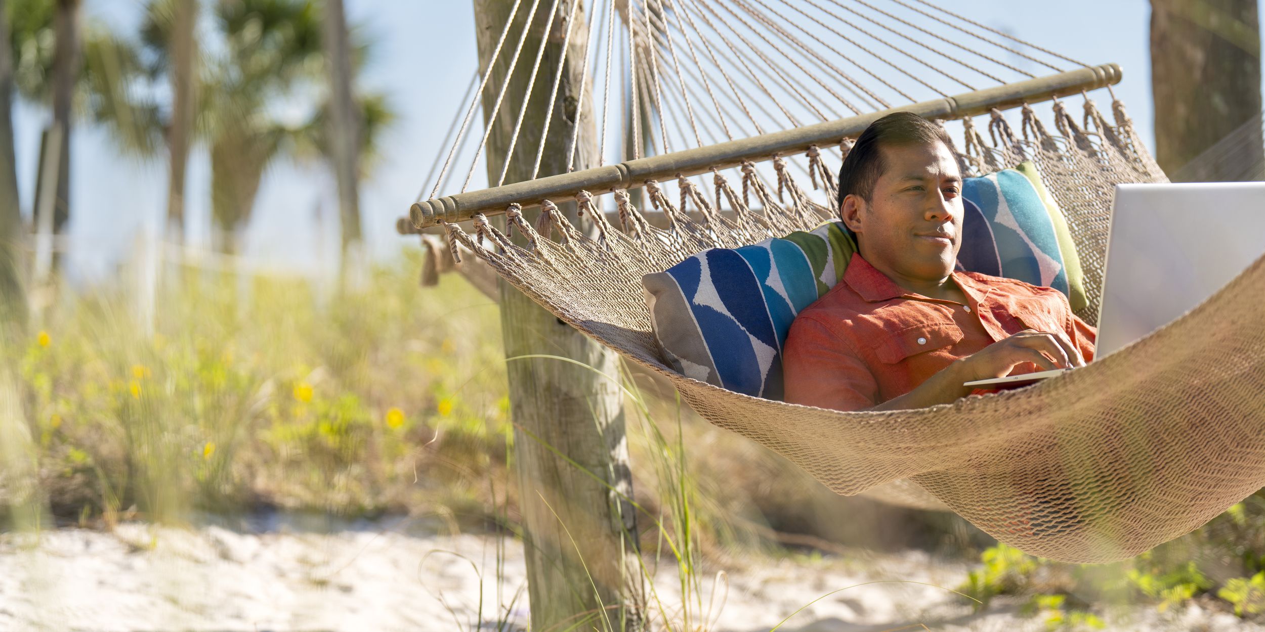 A Man Sitting On A Bed Next To A Body Of Water