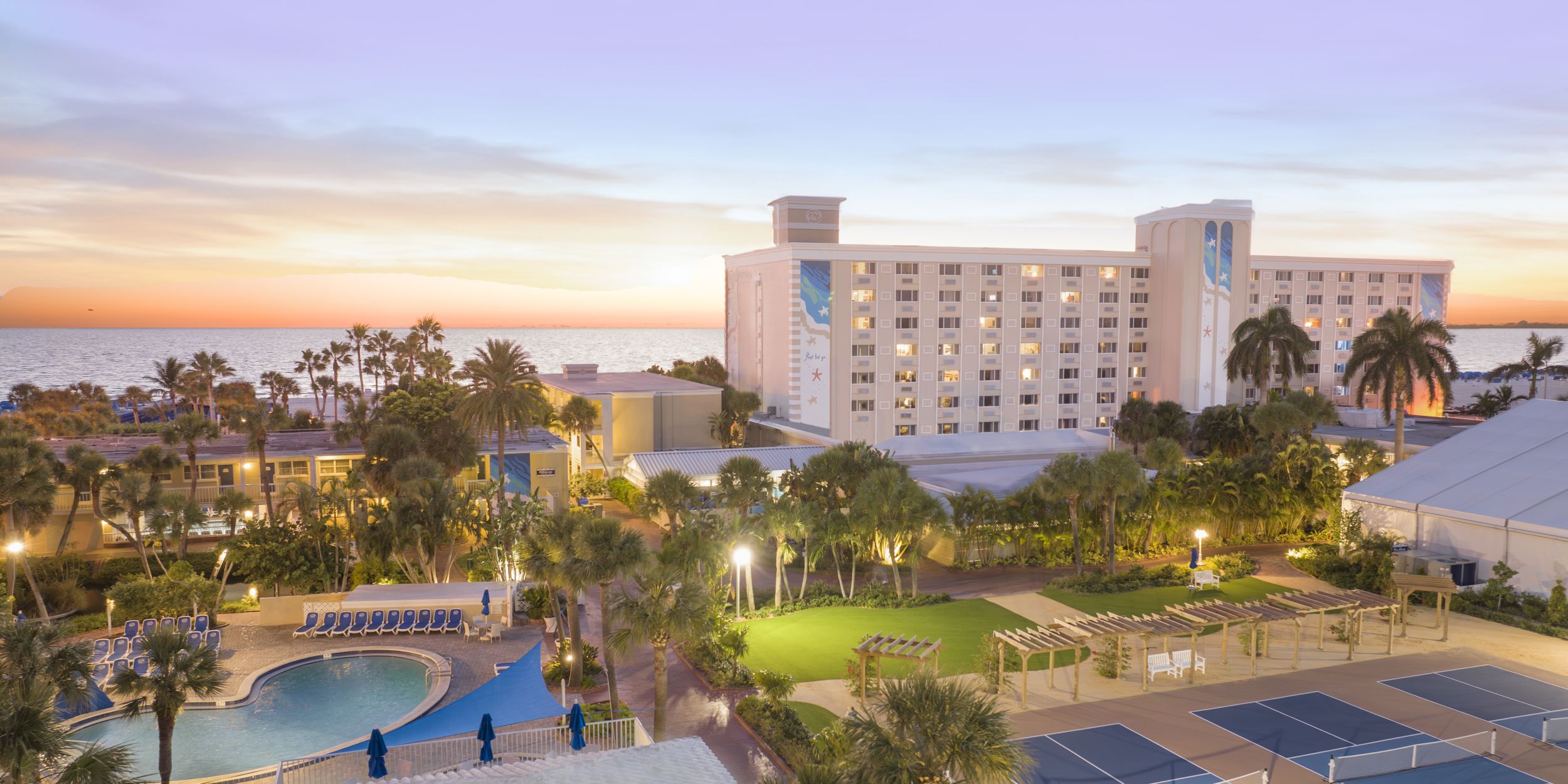 A Building With A Pool And Trees In Front Of It