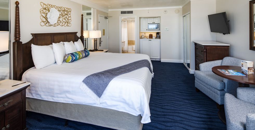 A Bedroom With A Bed And Desk In A Hotel Room