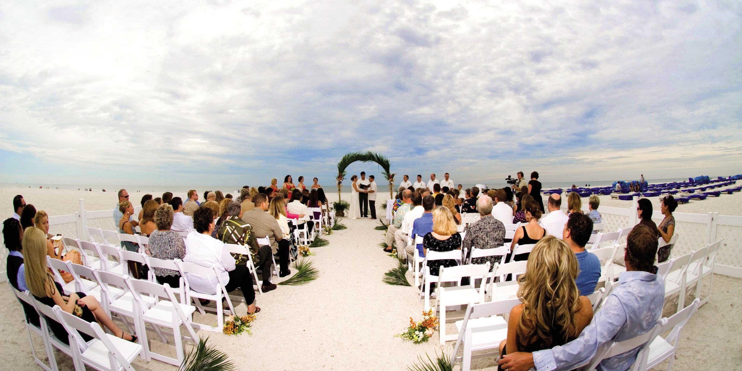 A Group Of People Sitting At A Beach
