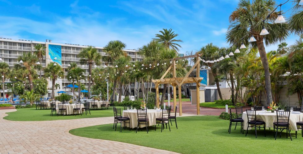 A Brick Patio With Tables And Chairs And Trees And Buildings In The Background